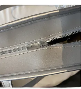 Dettaglio borsa tote argento metallizzato con cerniera liscia e manico di perle