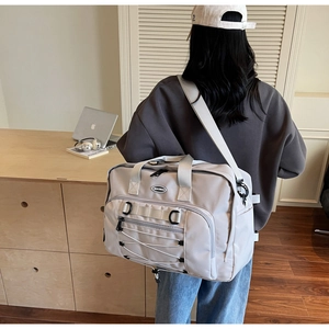 Detail view of the large capacity beige travel bag with adjustable strap and durable fabric