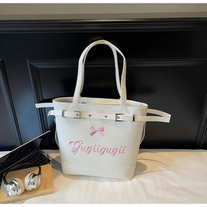 Gros plan du sac cabas crème avec décoration nœud rose et détails de broderie fins