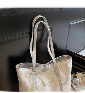 Borsa tote in pizzo con fiocco di perle e finiture in argento in un ambiente moderno di stile
