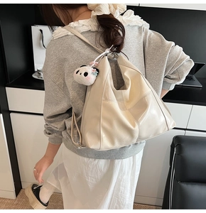 Détail d'un sac cabas multifonctionnel beige avec un joli porte-clés en peluche panda