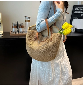 Détail d'un sac cabas en paille tissé main avec lanières en cuir pour les vacances