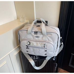 Close-up of light grey large capacity travel bag on luggage with NOCOBAG logo