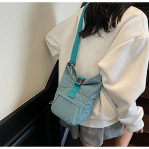 Détail de la bandoulière réglable sur un sac seau bandoulière léger en nylon bleu clair