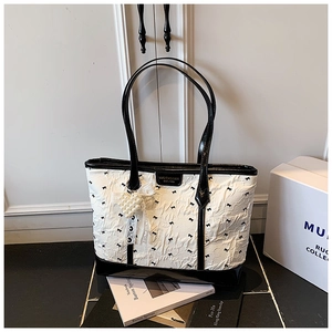 Close-up of contrast tote bag featuring white pleated texture and heart pearl pendant