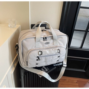 Detailed view of spacious travel bag with adjustable straps placed on a black suitcase