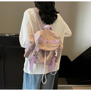 Dettaglio dello zaino in nylon lavanda che mostra la chiusura a coulisse e la tasca laterale