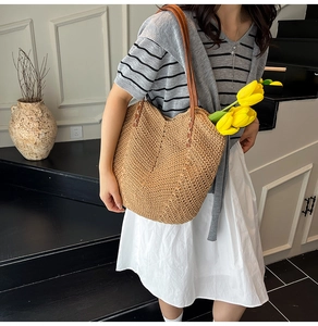 Détail du sac cabas en paille tressée avec anses en cuir marron et texture fine