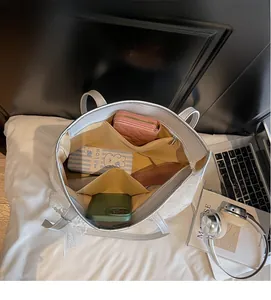 Vista interna di spaziosa borsa tote in pizzo bianco con tasche interne e zip