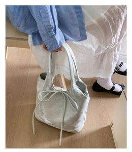 Close-up of a white tote bag with shimmering star glitter and a delicate bow detail