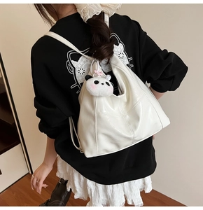 Détail du sac fourre-tout en cuir verni blanc avec charmant panda en peluche et surpiqûres