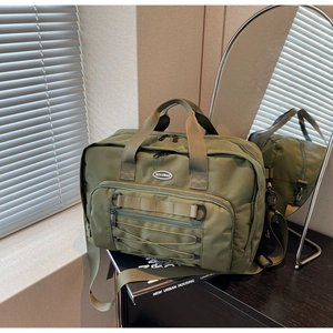 Detail of army green travel bag with adjustable straps and front pocket for storage
