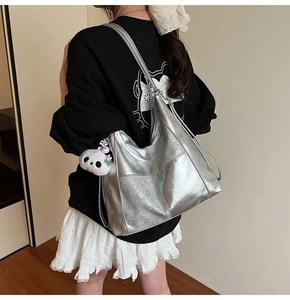 Détail du sac cabas argenté métallisé avec texture unique et pendentif panda décoratif