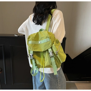 Dettaglio dello zaino in nylon verde erba con trama impermeabile e fibbia argento