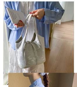 Detail of light grey tote bag featuring floral butterfly print and drawstring closure