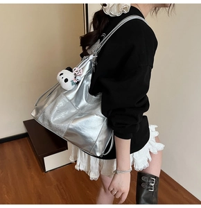 Détail du sac cabas argenté métallisé avec texture et porte-clés panda en peluche mignon