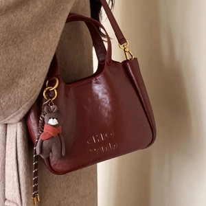 Retro burgundy leather handbag with gold ring handle and cute plush bear charm