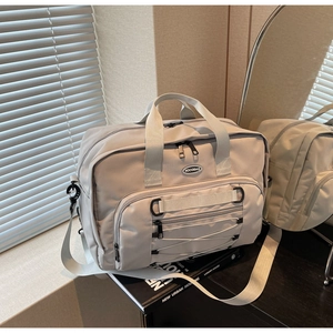 Detail of the durable nylon travel bag featuring the front bungee cord and logo
