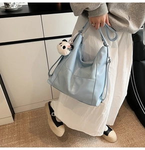 Détail du sac hobo bleu clair en similicuir brillant avec charmant pendentif panda