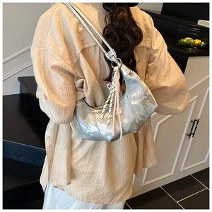 Detailed view of silver crescent dumpling bag with marble print and metallic charm