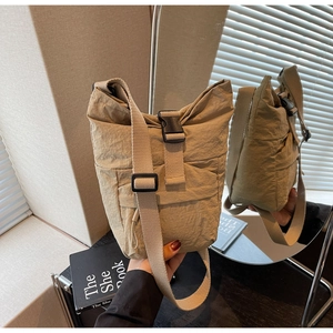 Detalle del bolso bandolera de nailon caqui con hebilla de plástico y correa ajustable