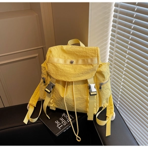 Dettaglio dello zaino in nylon giallo brillante con tessuto testurizzato e fibbie