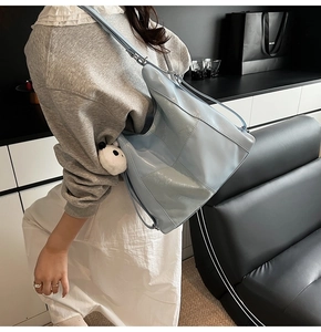 Détail du cabas matelassé bleu clair brillant avec adorable pendentif panda en peluche