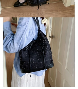 Close-up of black polka dot tote bag with bow detail and vintage underarm design