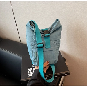 Primer plano del bolso bandolera de nailon impermeable azul grisáceo con hebilla negra