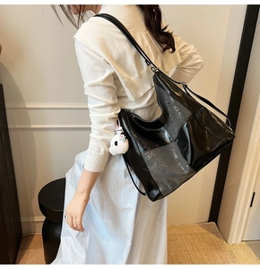 Détail du sac fourre-tout noir brillant matelassé avec pendentif lapin en peluche blanc