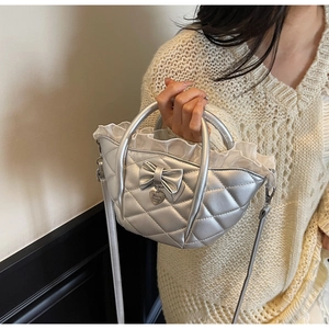 Detail of silver quilted bucket bag with leather bow and ruffled edge decoration