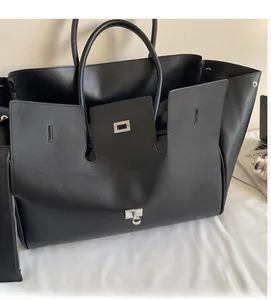Detail of black tote bag with silver metal lock, including a matching zipper pouch