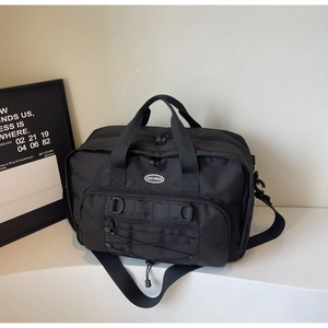 Detail of black nylon travel bag featuring adjustable straps and NOCOBAG logo
