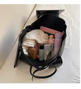Top view of large black faux leather tote bag showing spacious interior with laptop and items