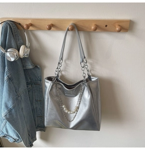Detail of silver metallic tote bag with pearl chain charms and pleated texture finish