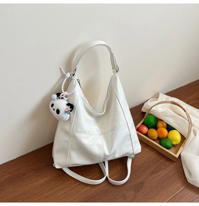 Vue détaillée du sac hobo blanc avec une surface texturée et un joli pendentif de panda