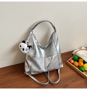 Détail du sac cabas argent métallisé avec doubles sangles et pendentif panda en peluche