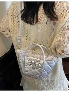 Silver quilted bucket bag with bow detail and heart charm for elegant summer styling