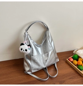 Détail du sac cabas argenté métallisé avec bandoulière et porte-clés panda en peluche