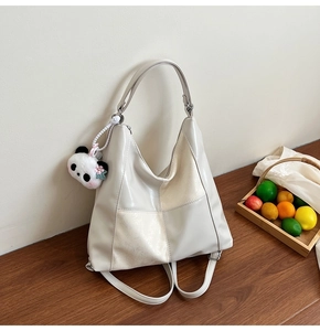 Détail du sac fourre-tout blanc cassé avec patchwork asymétrique sur une table en bois