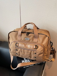 Brown large capacity travel bag with multi-compartments on a leather sofa