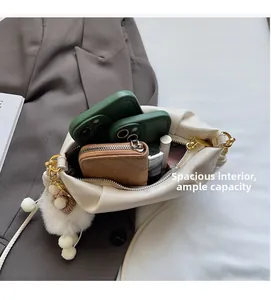 Spacious interior of off-white dumpling bag holding two phones and a wallet
