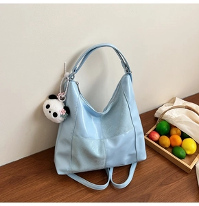 Détail d'un sac cabas en cuir PU bleu clair avec un joli charm panda en peluche sur le côté