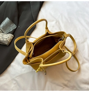 Top view of bright yellow pebble leather bucket bag with spacious interior and zipper compartment