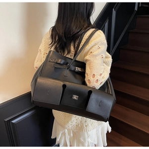 Detail of black leather tote bag featuring multiple pockets and silver twist lock closure
