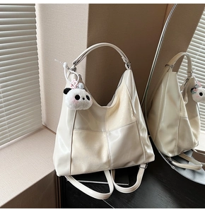 Vue détaillée du sac fourre-tout crème en patchwork avec pendentif panda en peluche