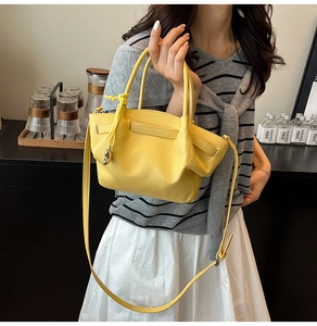 Detail of yellow lychee pattern leather bucket bag with silver ball charm and long strap