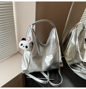 Gros plan détaillé du sac cabas argenté avec coutures en croix et un pendentif panda