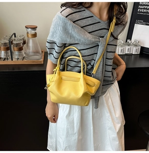 Close-up of bright yellow litchi pattern leather bucket bag with top handle and strap
