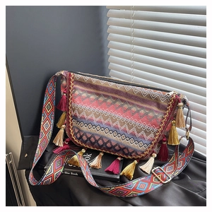 Detail of colorful geometric woven texture and tassel charms on Bohemian shoulder bag